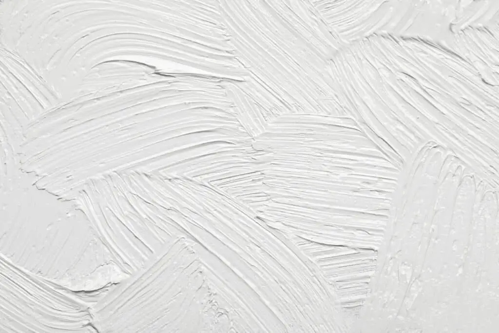 Strokes of white paint to create a textured wall.