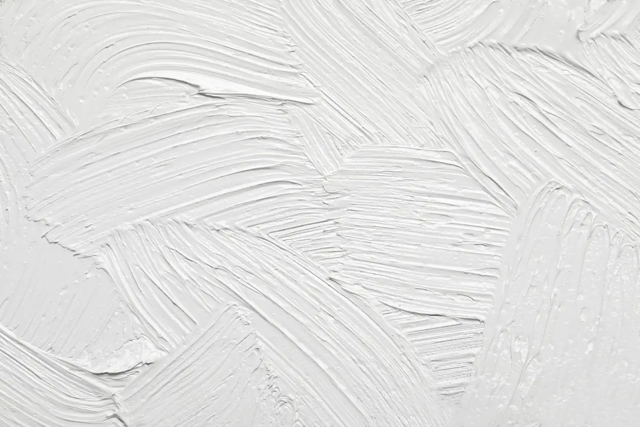 Strokes of white paint to create a textured wall.