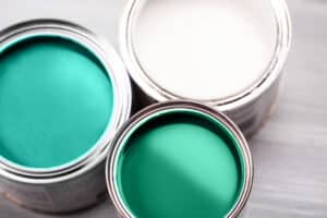 Several opened cans with green paint inside. Flat lay style