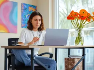 woman using laptop while working in a home office space