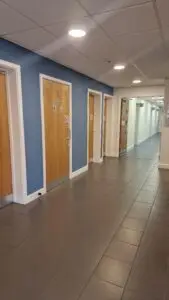 Freshly painted hallway in blue and white with multiple doors in a commercial building in Leicester.