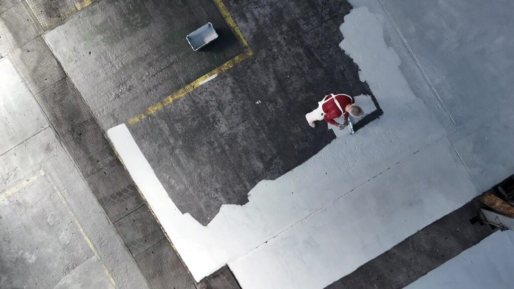 Commercial painter in Leicester applying industrial floor coating in a warehouse to enhance durability and safety