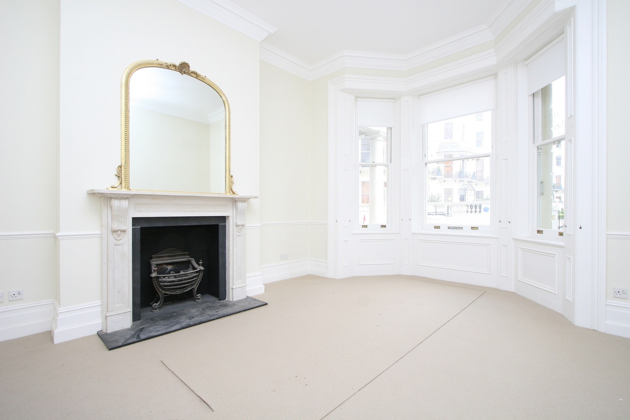 Freshly decorated living room in a period property, featuring an original fireplace and sash windows